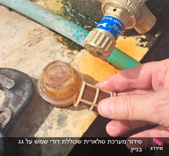 יד מחזיקה מסנן ליד ברז וצינור